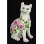 A Weymss pottery cat with green glass eyes and painted in 'cabbage rose' pattern, impressed mark