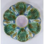 A John Holdcroft shaped majolica six-well oyster dish with central circular well, decorated in green