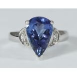 An 18ct white gold ring set with a pear shaped tanzanite, with a round brilliant-cut diamond to each