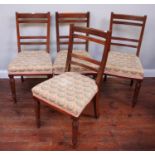 A set of four stained walnut standard dining chairs, with stuff-over seats on turned and tapering