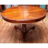 A mahogany circular dining table raised on baluster support to three pedestal carved legs, approx.