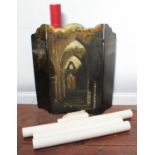 A Victorian black lacquered fire screen painted with a scene of a church ruin and highlighted with