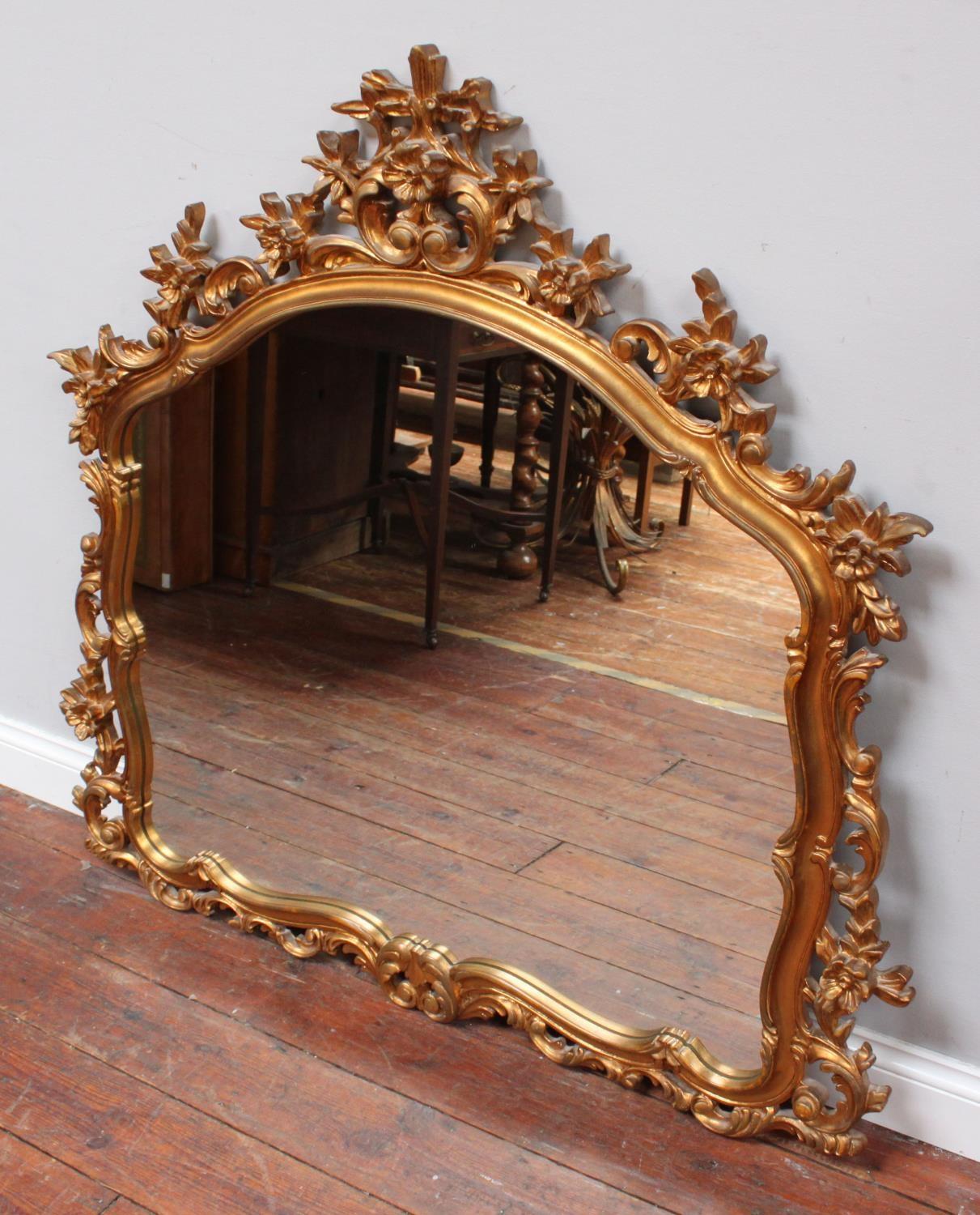 A large over-mantel mirror in ornately carved, foliate gilt frame, 120cm wide