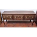 An 18th century oak three-drawer dresser on cabriole supports, with later Victorian scrolling