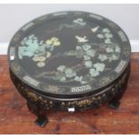 A circular Chinese lacquer coffee table with glass top over applied carved green hardstone landscape