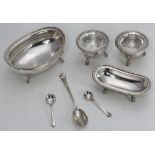 A white metal condiment set comprising two open salts with glass liners and two small serving dishes