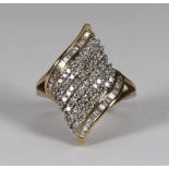 A 9ct gold and diamond dress ring of fancy-swirl design, pave-set to the central band with