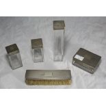 A five piece dressing table set comprising four square glass jars with engine turned silver covers