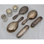 A four piece silver-backed brush set engraved with floral sprays, Birmingham, 1911, together with