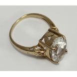 A 9ct gold dress ring, centrally claw-set with a large oval faceted clear stone, possibly a white