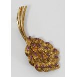 An 18ct gold and ruby brooch modelled as a stylised floral bouquet, claw-set with thirty-six small