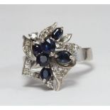 An 18ct white gold, diamond and sapphire ring modelled as a stylised leaf spray with six