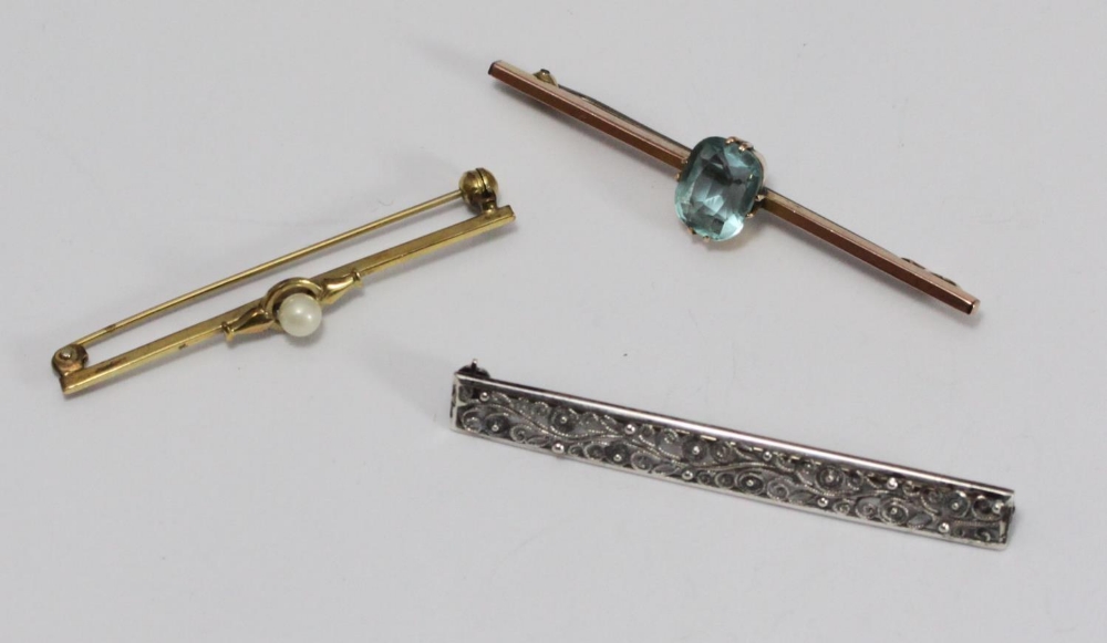 A 9ct gold bar brooch centrally set with an oval faceted aquamarine, together with a yellow metal