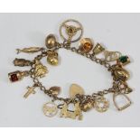 A 9ct gold charm bracelet hung with twenty charms including a steering wheel, starboard and port-