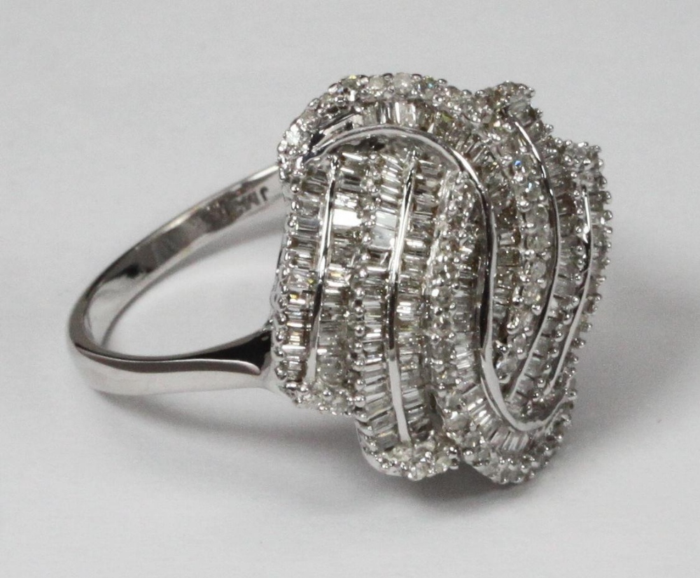 A 9ct white gold multi-row swirl design ring set with baguette and round brilliant cut diamonds. The - Bild 2 aus 3