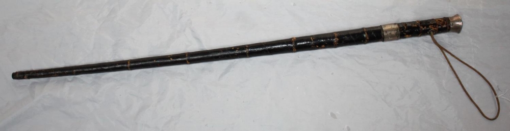 A sword stick with white metal collar and handle, black painted bamboo grip and triform blade, in