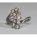 A ten-stone diamond ring, of fancy ?fan? design, claw set in unmarked white metal, estimated total