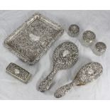 A silver dressing table set comprising a rectangular tray, hand mirror, brush and four various