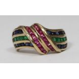 A 9K ruby, sapphire and emerald ring, of cross-over swirl design, channel set, with 10x round-