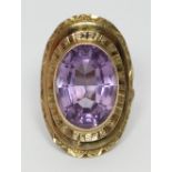 A 9ct gold dress ring, of three-tiered oval design, centrally set with a large oval faceted amethyst