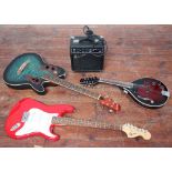 A Stagg electric Mandolin, together with a Squire Strat by Fender electric guitar in red, a round-