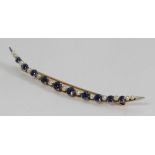 An unmarked yellow metal seed-pearl and sapphire crescent brooch (tests as 9ct), 5.39g