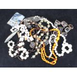 A small quantity of costume jewellery including an amber-coloured bead necklace, white metal