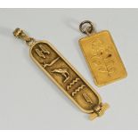 An 18ct hieroglyph pendant, 3.1 grams, together with a fine gold pendant weighing 2.7 grams, (2)