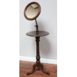 A Victorian shaving stand with adjustable mirror, raised on tripod base