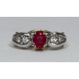 An 18ct yellow gold, ruby and diamond ring, centrally claw-set in rhodium-plated top with an oval