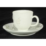 A Bow porcelain Fujian style blanc-de-chine coffee cup and saucer with applied flowering prunus,