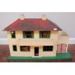 A wooden dolls house with balcony, the front opening to reveal the fitted interior of a house,