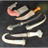 Three assorted Jambiya daggers, one with agate mounted grip and scabbard and brass detailing,