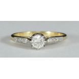 An 18ct gold and platinum solitaire diamond ring claw-set with a RBC diamond and three small