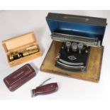 A Frolio, Model III portable typewriter on wooden base with black metal cover, together with a brass