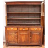 An 18th century oak kitchen dresser, the raised, planked back with three shelves, above a base