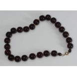 A modified Baltic amber bead necklace, twenty-four spherical beads, approx. 15mm diam, and two small