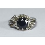 A platinum dress ring claw-set with a central round sapphire in a diamond set twist design mount.