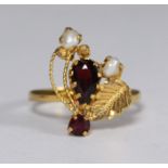 A high carat unmarked gold garnet and seed pearl dress ring weighing 3.5 grams. Ring size L