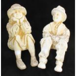 A pair of composition stone garden figures modelled as a seated man and woman, designed to sit on