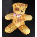 A vintage stuffed teddy bear with pink bow around neck and a bell in each ear, 36cm tall when seated