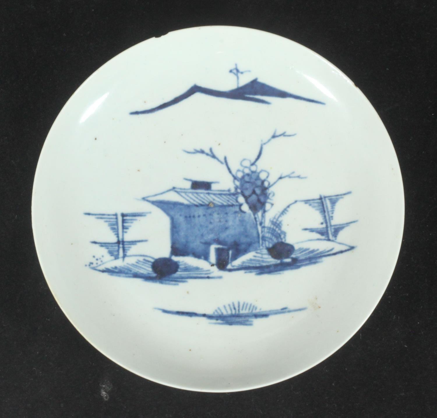 A Longton Hall porcelain saucer decorated in underglaze blue with a chinoiserie landscape, chip to