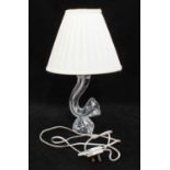 A Daum clear glass table lamp, of organic cornucopia form, 24cm high, with cream shade