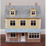 A large dolls house with front porch and dormer windows to lift-up roof together with a small