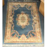 A large machine-made Chinese rug with central floral cartouche and floral borders, decorated in