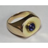 A 14ct gold signet ring with a central cabochon cut sapphire coloured stone, stamped inside 'Just