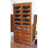 An oak haberdashery unit arranged in two columns, twelve glazed drawers above eight plain drawers,