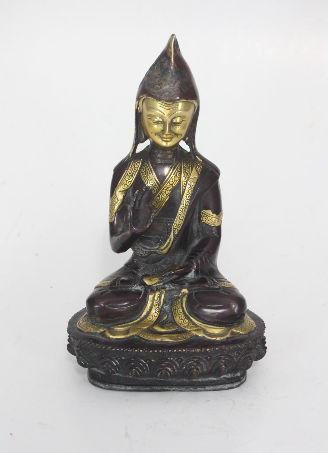 A patinated bronze figure of a seated Buddha, 21cm tall