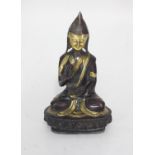 A patinated bronze figure of a seated Buddha, 21cm tall