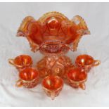 An amber coloured Carnival glass punch bowl on stand, together with five cups